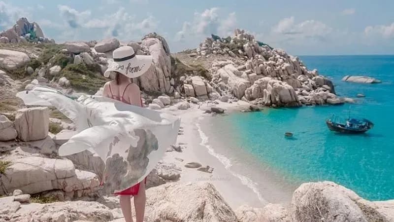 A visitor enjoying the tranquil scenery at Ca Na Beach, featuring soft white sand.