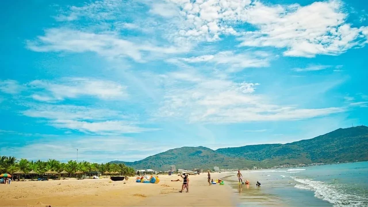 Beach activities with scenic mountains in the background.