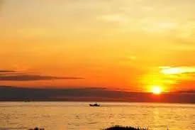 Stunning sunset over Bao Ninh Beach with warm orange hues.  