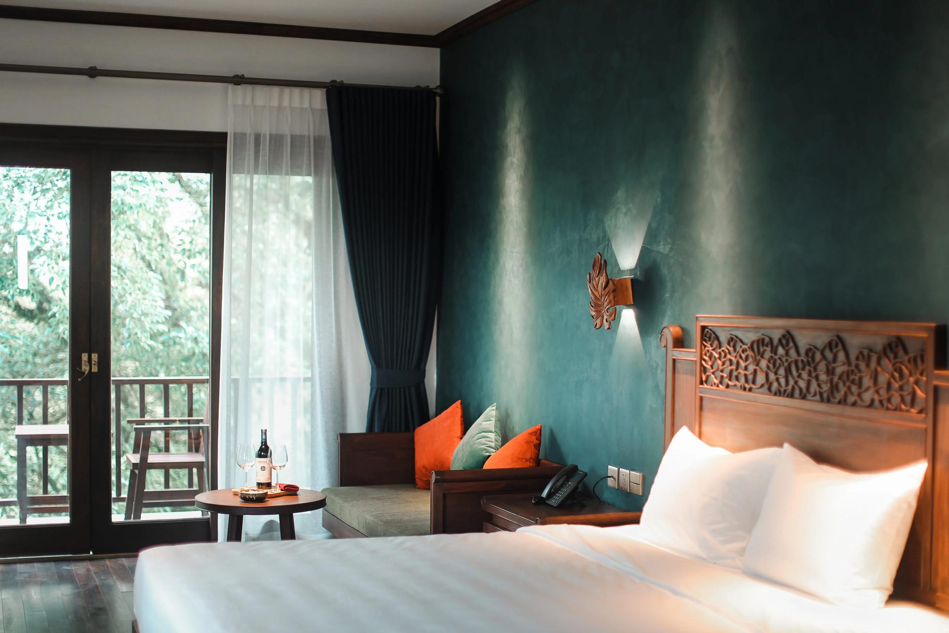 Luxurious bedroom with forest-view balcony at Amour Resort.