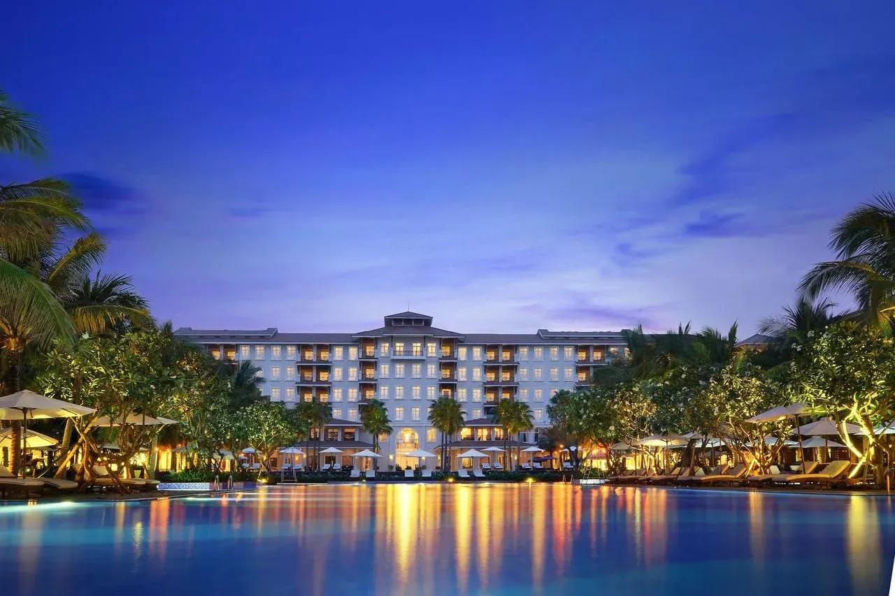 Vinpearl Luxury Da Nang hotel glowing at night by the pool.