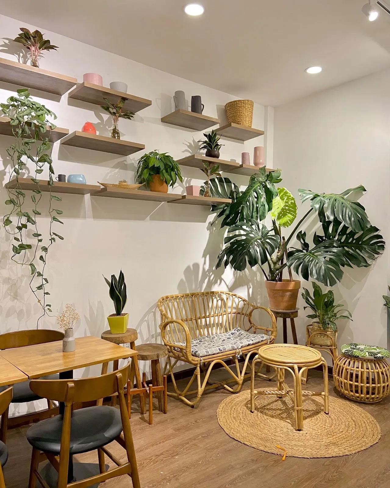 Coffee shop corner featuring bamboo furniture and greenery.