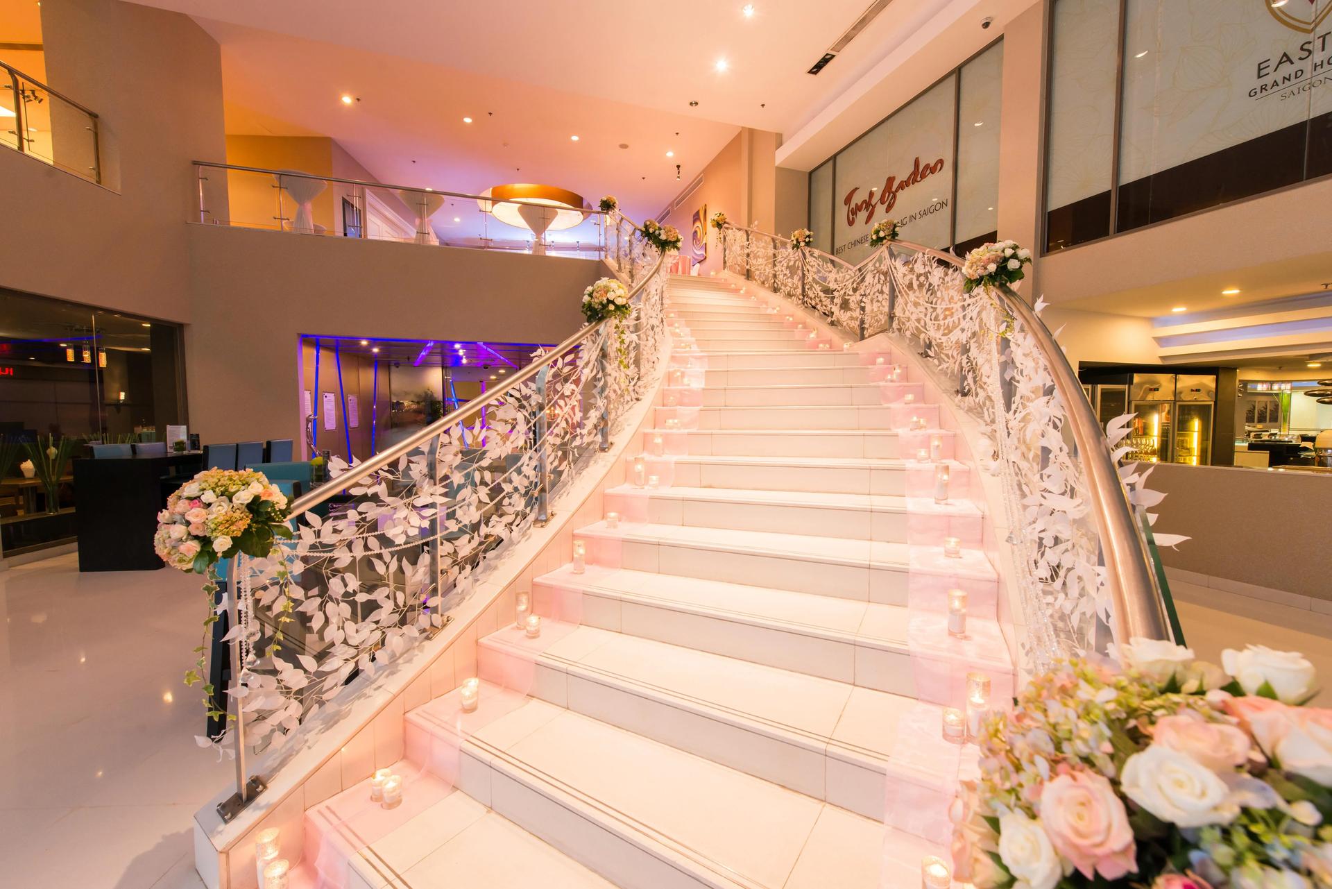 The staircase adorned with flowers and candles at Eastin Grand Hotel Saigon gives a romantic feel.
