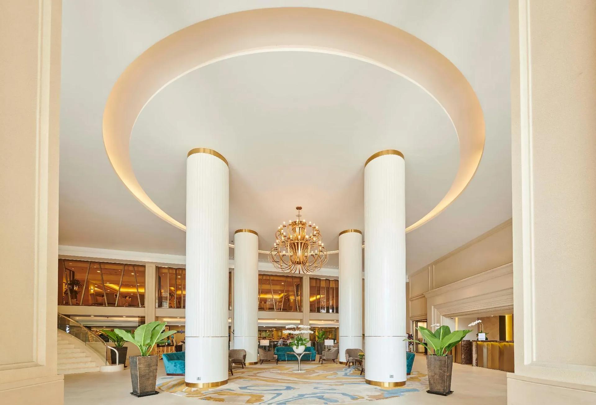 The grand lobby of Eastin Grand Hotel Saigon with high ceilings and exquisite chandeliers.