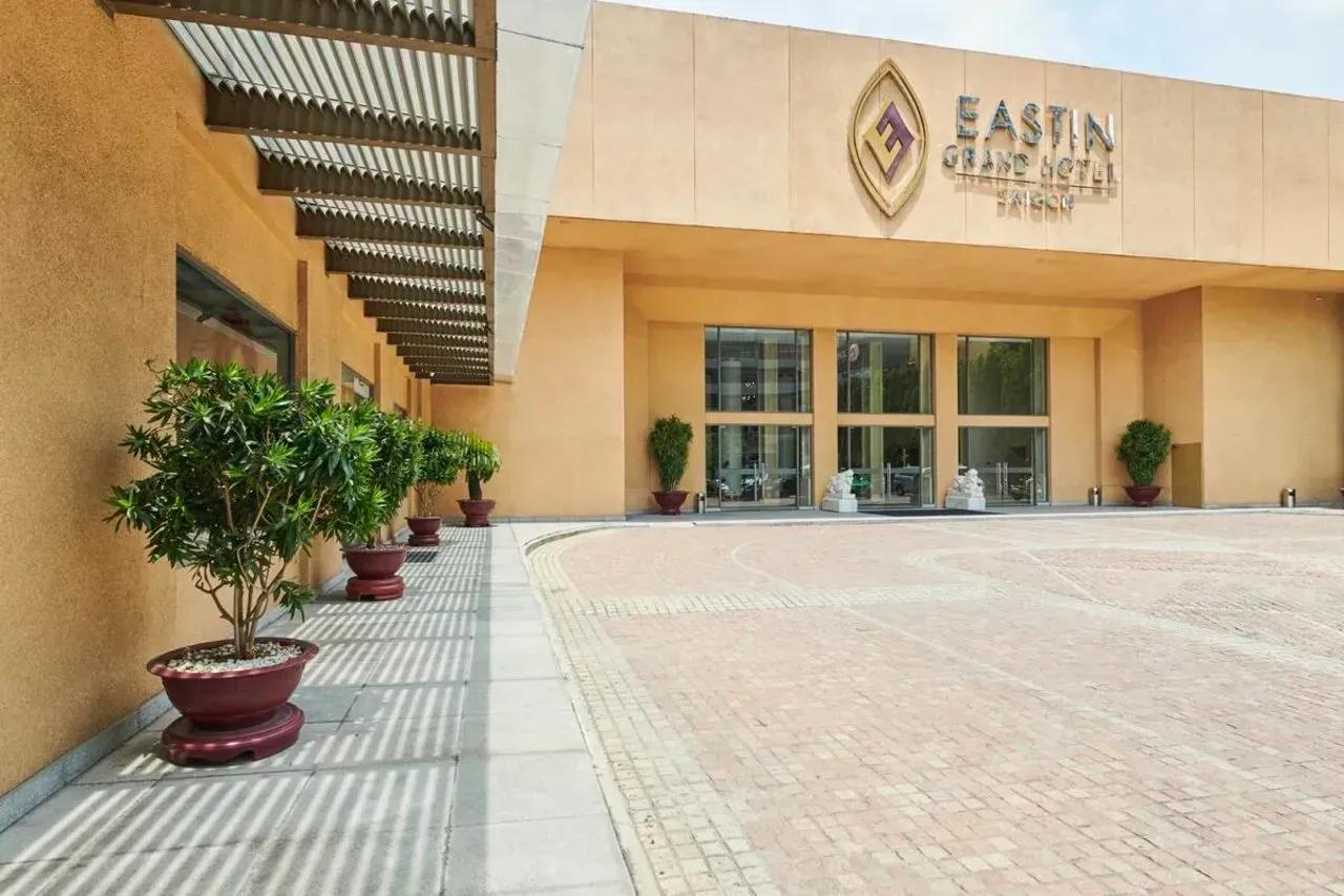 The elegant facade of Eastin Grand Hotel Saigon featuring a modern entrance and decorative greenery.