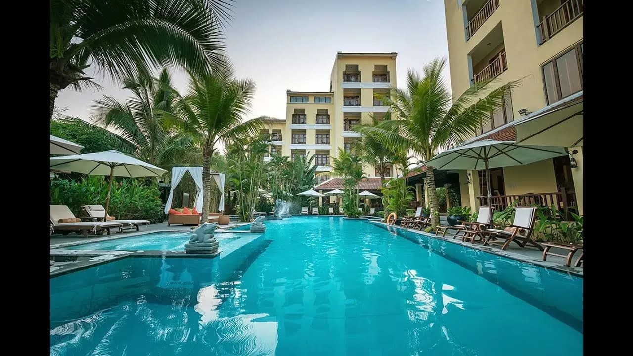 Hotel with refreshing pool amidst tropical setting.