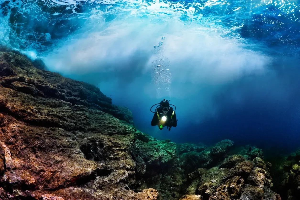 A scuba diver explores the vibrant coral reefs at Hon Chao, surrounded by colorful marine life and clear blue waters, capturing the underwater beauty of Vietnam’s coastline